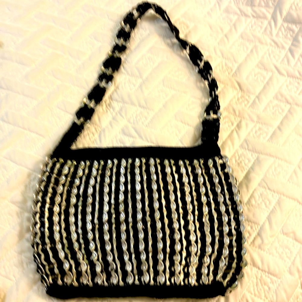 Cute. Crocheted PURSE.
Crafted with black thread and pop-tops